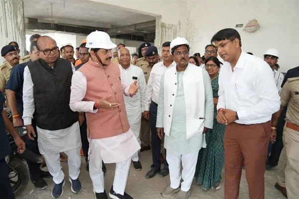 निर्माणाधीन भवन में सफेद हेलमेट पहने मुख्यमंत्री डॉ. मोहन यादव अधिकारियों के साथ निरीक्षण करते हुए