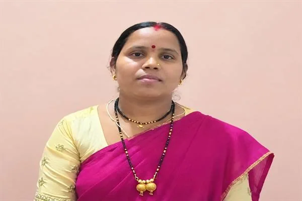 गुलाबी साड़ी पहने एक महिला का सामने से लिया गया चित्र